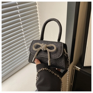 Detailed shot of black sequin mini handbag with sparkling silver rhinestone bow decoration