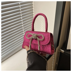 Close-up of fuchsia sequin mini bag featuring a luxury rhinestone bow and gold chain strap