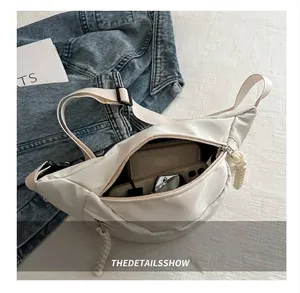 Interior view showing large capacity of the beige nylon crossbody chest bag for daily items