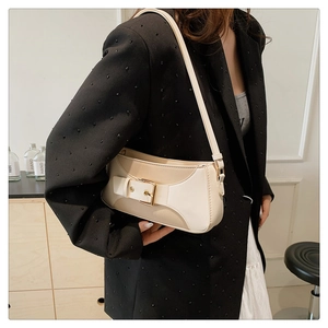Detail of color-block shoulder bag with gold square buckle shown on black blazer
