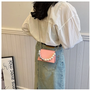 Détail du mini sac bandoulière rose avec poignée en perles et chaîne argentée