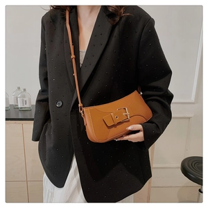 Caramel brown leather shoulder bag with gold square buckle shown on a model
