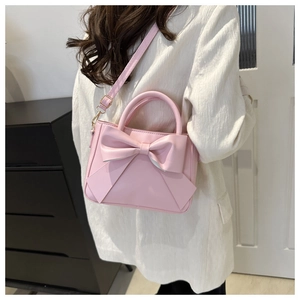 Dettaglio ravvicinato di una borsa in pelle PU rosa con un grande fiocco 3D elegante