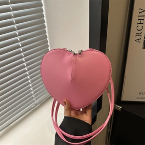 Pink heart-shaped faux leather shoulder bag with silver dual zippers and long strap