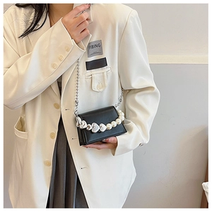 Détail du mini sac bandoulière noir avec décorations perles cœur et chaîne à billes