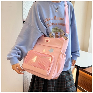 Detail der rosa Canvas Umhängetasche mit Netztasche und Stern-Patch-Zubehör
