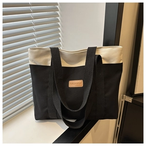 Détail d'un sac cabas en toile minimaliste avec couleurs contrastées et patch en cuir mode