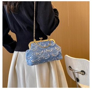 Detail of blue sequin beaded evening bag with gold chain strap on a model shoulder