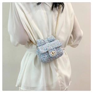 Detailed texture of blue tweed mini bag with bow accent and gold chain strap