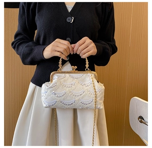 Dettaglio della borsa in pizzo bianco con paillettes argento e chiusura dorata vintage