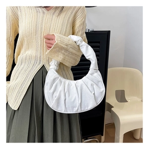 Gros plan détaillé d'un sac demi-lune en velours côtelé blanc avec texture plissée chic