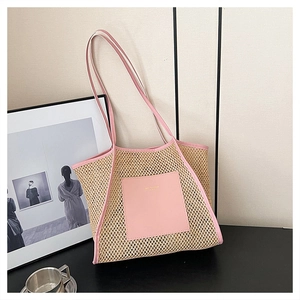 Detail der gewebten Strohtasche mit rosa Lederbesatz und elegantem goldenem Schriftzug