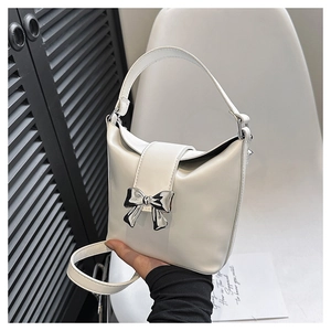 Detail of off-white PU leather handbag with a silver butterfly metal clasp buckle