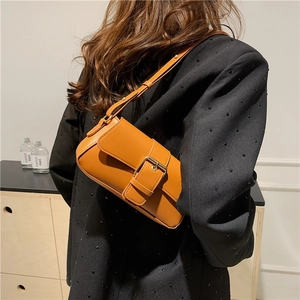 Ginger brown vintage faux leather shoulder bag with buckle strap worn with black blazer