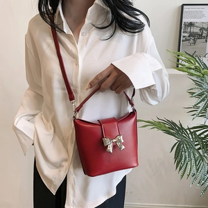 Red butterfly buckle bucket bag with top handle and shoulder strap for women