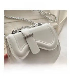 Macro detail of white ripple flap bag featuring silver metal bar lock and chain strap