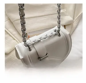 Detail of white saddle bag showing leather material and silver metal chain strap