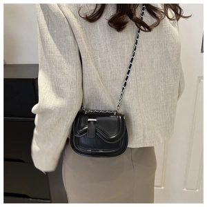 Model wearing a black mini PU leather crossbody bag with silver chain strap details
