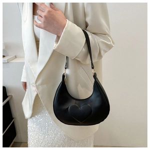 Détail du sac croissant noir avec relief en forme de cœur et anneau métallique doré élégant
