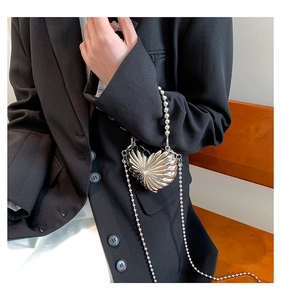 Détail du mini sac cœur argenté avec texture plissée métallique et chaîne à billes