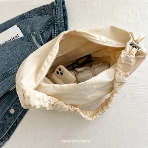 Detail view of large beige canvas tote bag showing interior space for daily items