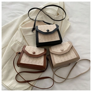 Détail de sacs bandoulière matelassés en noir, marron et beige avec textures mixtes