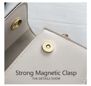 Détail du fermoir magnétique doré puissant sur le sac à bandoulière minimaliste en cuir