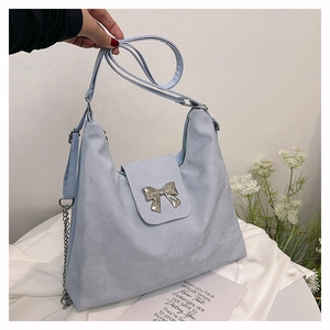 Close-up of light blue hobo bag with silver bow detail and dual shoulder strap options