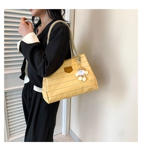 Detail of yellow checkered canvas tote with hemp rope straps and white plush pendant charm