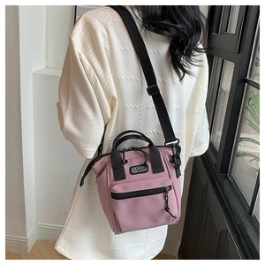 Detail van de roze canvas crossbodytas met S SPORT-logo gedragen door een model