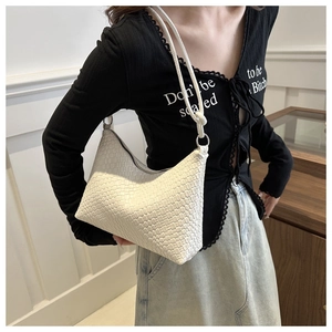 Dettaglio della trama in pelle intrecciata bianca di una borsa a spalla con anelli argento