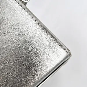 Detailed macro shot of silver cracked leather material with precision white stitching