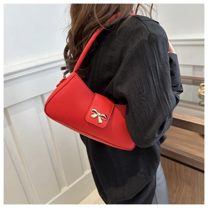 Sac bandoulière rouge avec nœud porté par un mannequin montrant le style et la taille