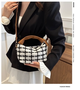 Dettaglio borsa a tracolla in tweed bianco e nero con manico in pelle marrone