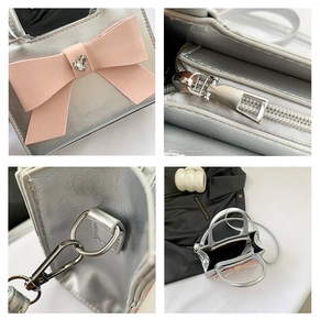 Detail of silver pleated crossbody bag with pink bow and heart gemstone accent