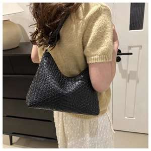 Dettaglio della borsa hobo in pelle intrecciata nera con texture Intrecciato e tracolla