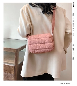 Bolso bandolera cuadrado acolchado rosa con costuras sobre modelo con blazer blanco