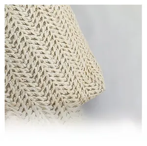 Gros plan sur la texture tissée en V d'un grand sac de plage en paille beige