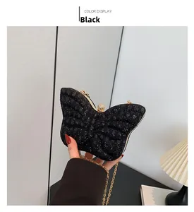 Detalle de bolso de noche mariposa negro con lentejuelas y correa de cadena dorada