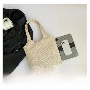 Gros plan détaillé du sac cabas en paille beige avec motif de tissage en chevrons chic