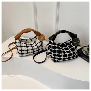 Detail van stijlvolle geruite tweed tassen met leren handvatten en metalen hardware details