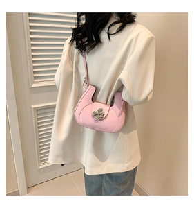 Détail du sac demi-lune en cuir rose avec boucle fleurie argentée et bandoulière