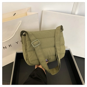 Detalle del bolso bandolera acolchado verde militar con textura suave y correa ajustable