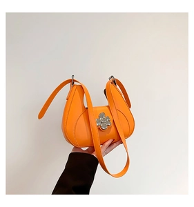 Détail d'un sac demi-lune orange vif avec fermoir fleur en métal et finitions argentées