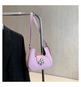 Détail du sac demi-lune rose avec boucle fleurie argentée et bandoulière en cuir
