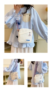 Vue détaillée du sac bandoulière en toile blanche avec bandoulière violette et étiquette