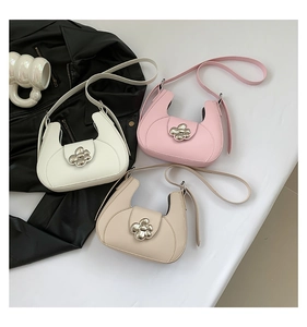 Trois sacs demi-lune en blanc, rose et beige avec des boucles fleurs en métal