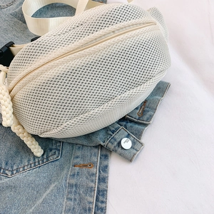 Detailed close-up of white mesh fanny pack featuring a textured honeycomb fabric design