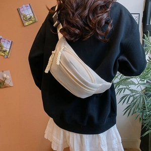 Detail of breathable cream mesh waist bag with double zippers and black buckle strap