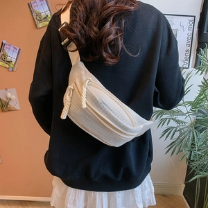 Detail of white mesh crossbody bag with dual zippers and rope pulls on model